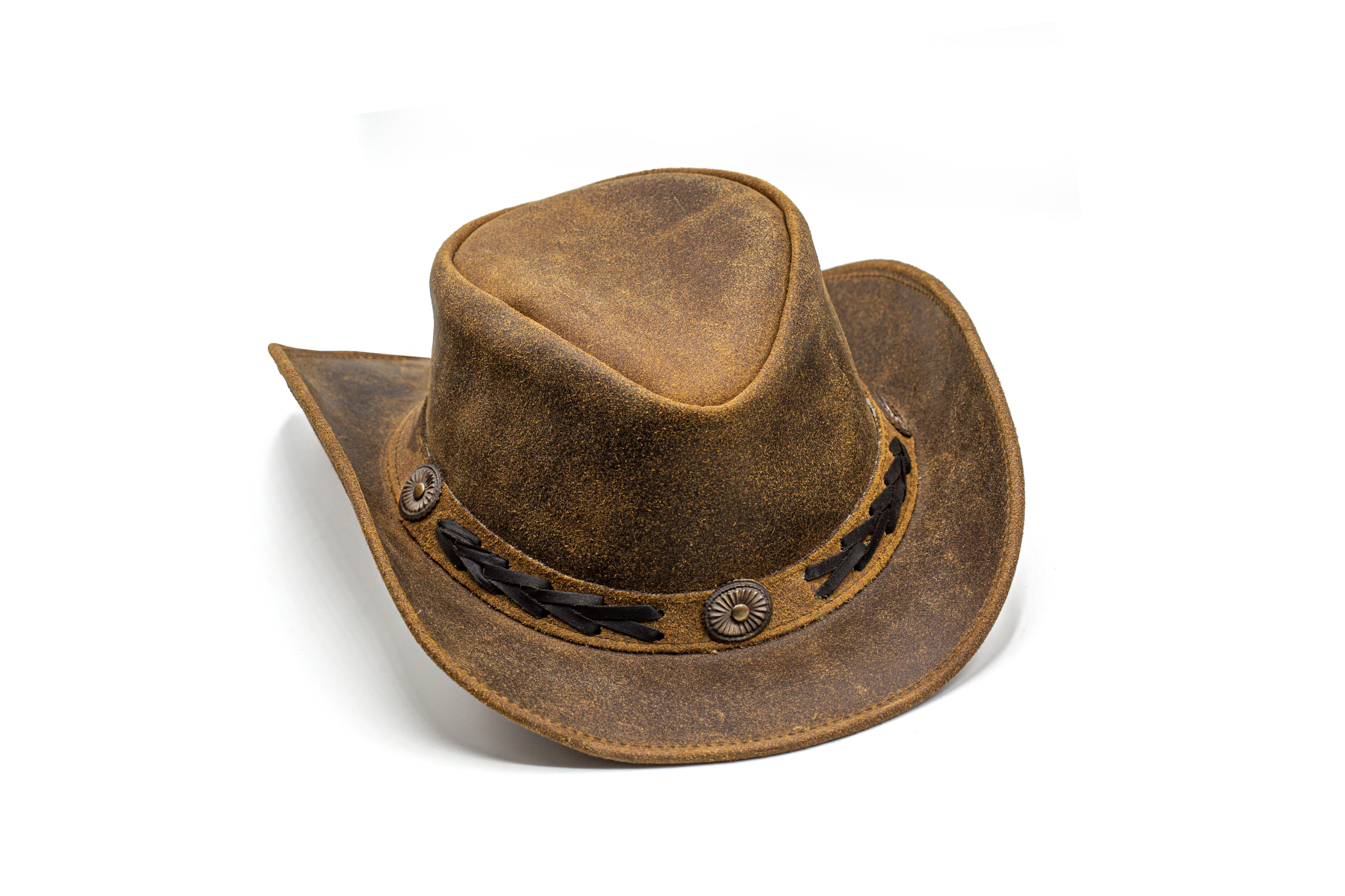 Black western style cowboy hat on a bale of hay with chaps and a